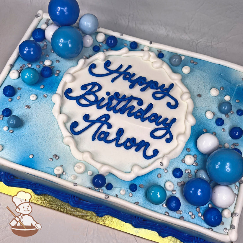 Sheet cake with blue and white buttercream decorations, featuring bubble toppers in various sizes and shades of blue and white, with silver sprinkles.