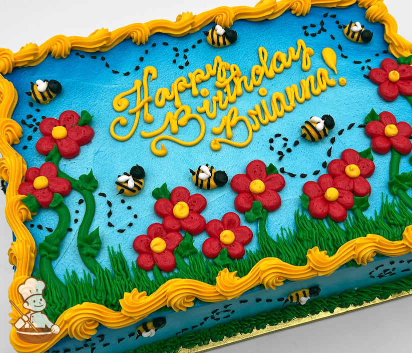 Sheet cake with blue base, red daisies with yellow centers, green leaves and grass, buzzing bees with black dotted flight paths, and yellow border frosting.