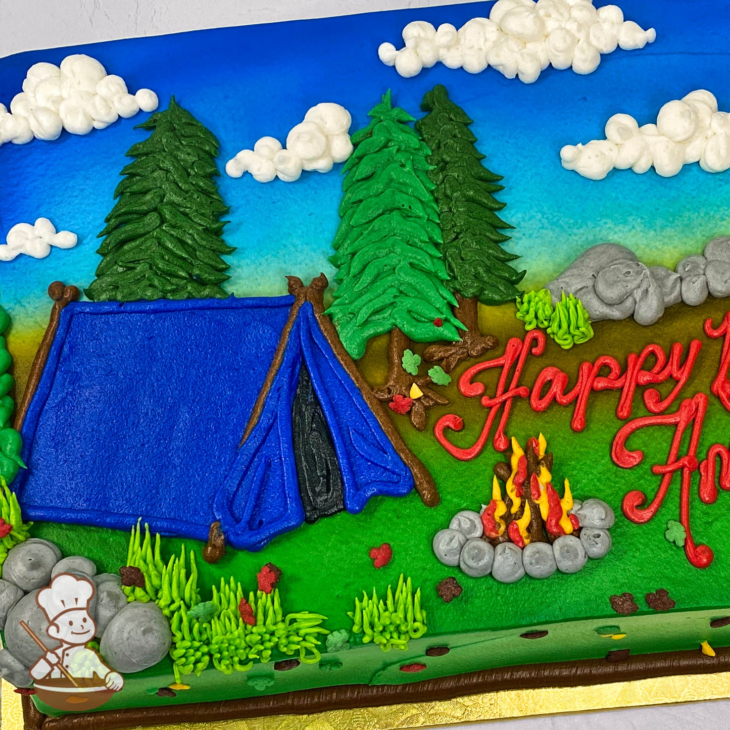 Sheet cake decorated with buttercream designs of a blue tent, green trees, gray rocks, a campfire with flames, white clouds, and a blue sky.