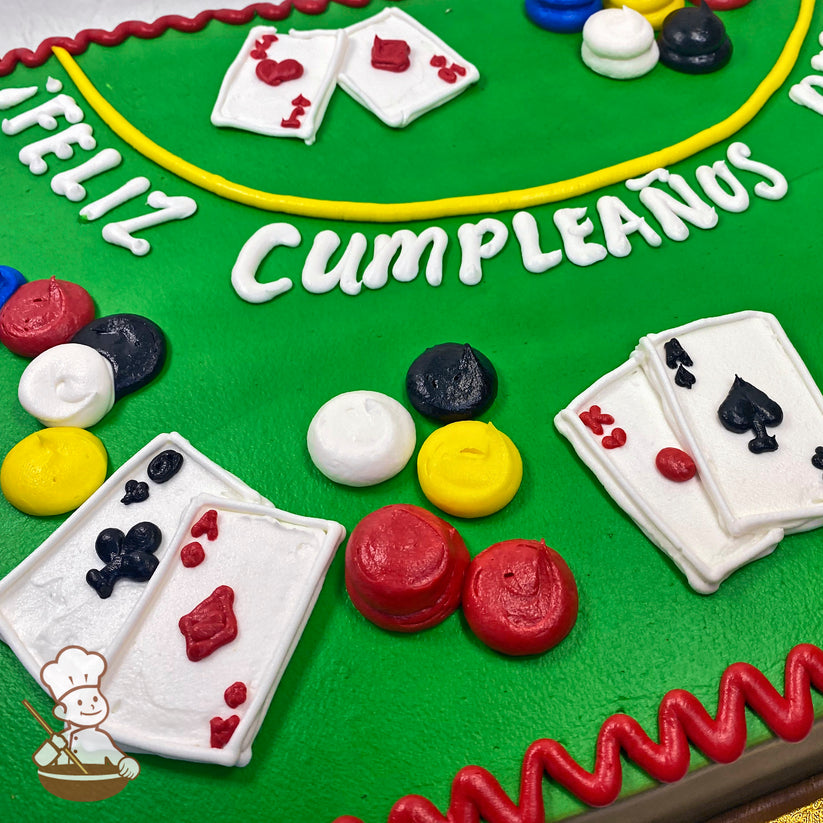 Sheet cake with green background, decorated with playing cards and poker chips in red, black, yellow, and white frosting. Red frosting border.