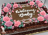 Sheet cake with buttercream decorations, pink roses, green leaves, white piped accents, and rose border design.