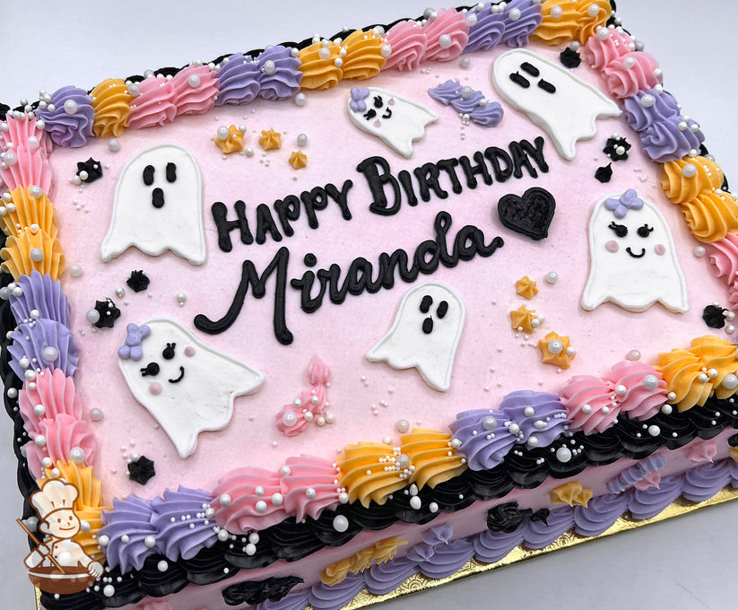 Sheet cake with pink base, decorated with white ghost shapes, pastel bows, yellow stars, and piped borders in pink, purple, yellow, and black.