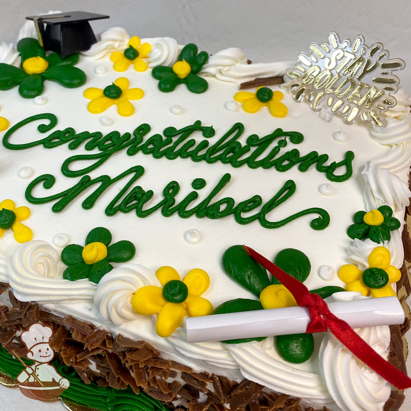 Sheet cake with white frosting, decorated with yellow and green buttercream daisies, a plastic graduation cap, a diploma decoration, and a "Stay Golden" topper.
