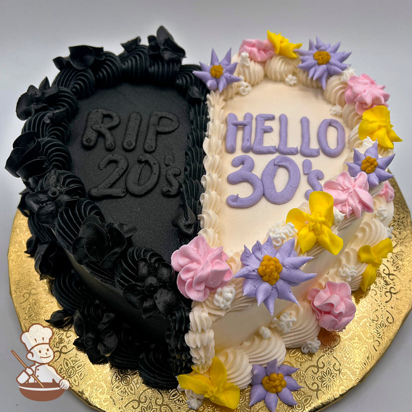 Half-black and half-beige heart cake, decorated with black buttercream flowers on the black side and pastel buttercream flowers—in yellow, purple, and pink—on the beige side.