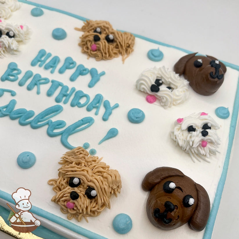 Sheet cake with buttercream dog faces, including brown and white dogs, and blue dots. Blue and green piping decorates the borders.