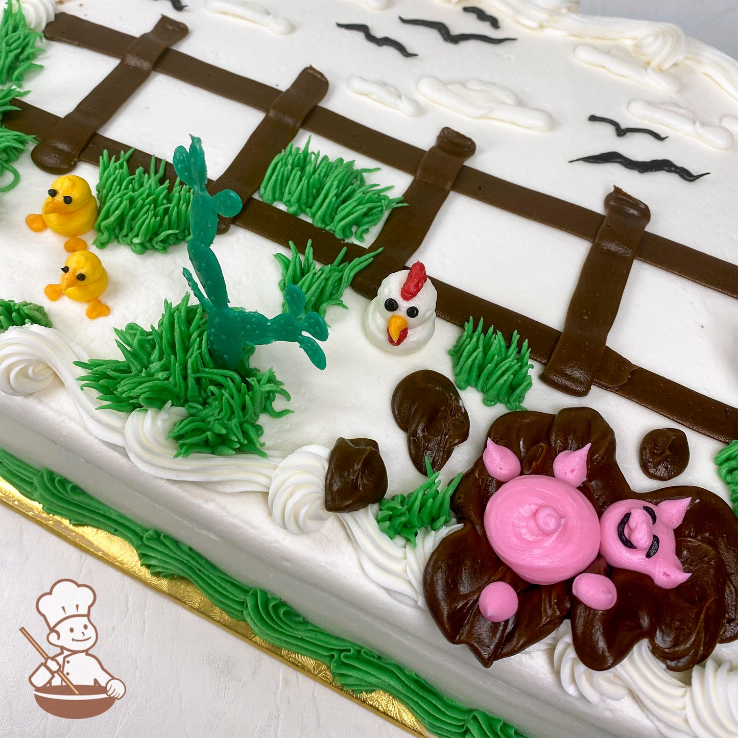 Sheet cake with buttercream farm animals: yellow chicks, a white chicken, a pink pig in mud, green grass, and a brown fence.