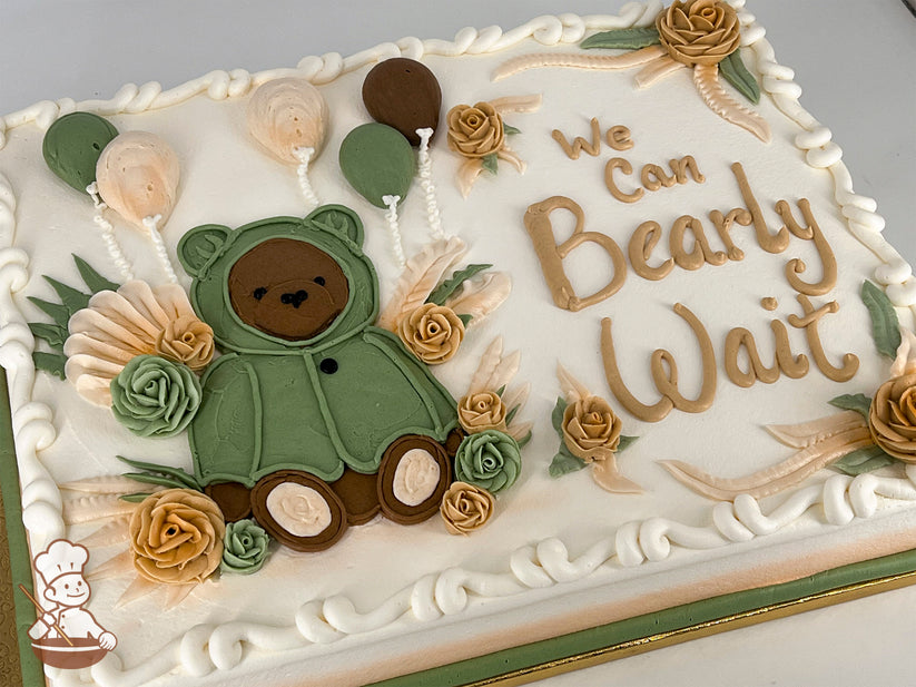 Sheet cake with buttercream decorations, featuring a hand-piped bear in a green sweater, surrounded by roses, balloons, and leafy accents.