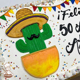 Sheet cake with buttercream decorations, featuring a hand-piped cactus in a sombrero and pot, colorful banner, confetti sprinkles, and piped white border.