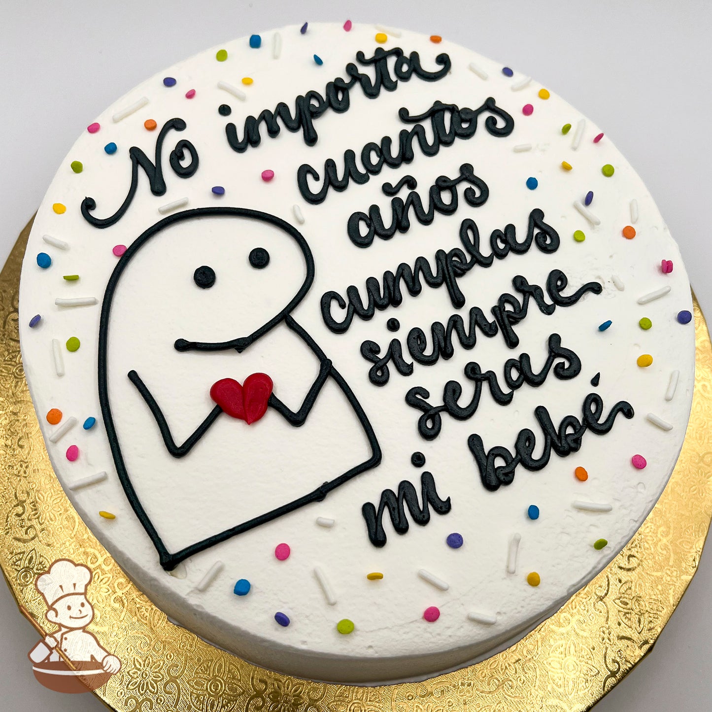 Round cake with white frosting, a hand-piped Flork meme holding a red heart, surrounded by colorful sprinkles on a gold base.