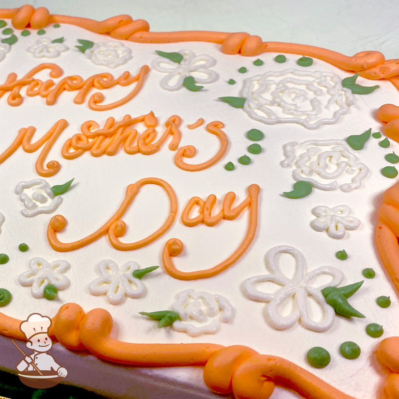 Sheet cake with orange buttercream border, white piped flowers, and green leaves.