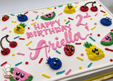 Sheet cake with hand-piped buttercream fruits, including cherries, blueberries, pineapples, strawberries, and watermelon slices, surrounded by colorful sprinkles.