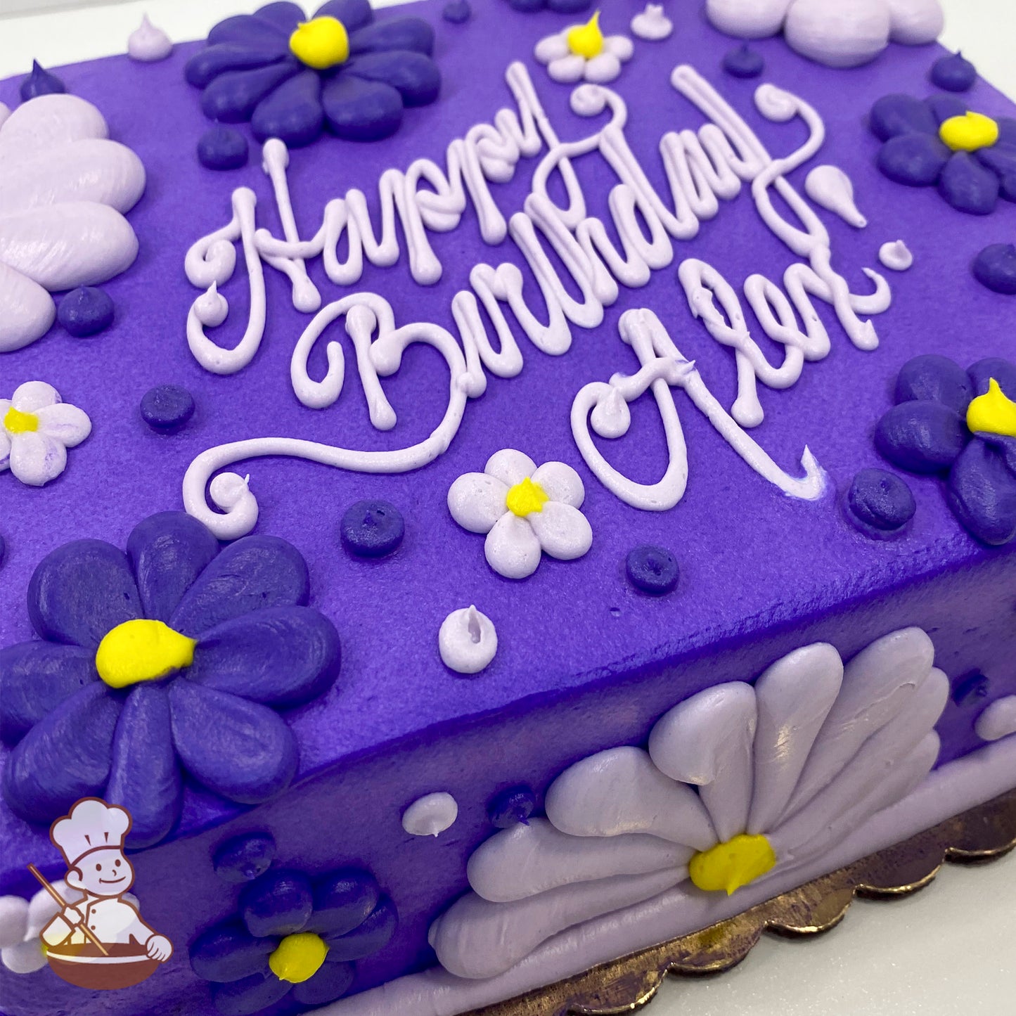 Purple sheet cake with buttercream decorations, featuring purple and lavender Gerbera daisies, small daisy flowers, and yellow centers, accented with dots.