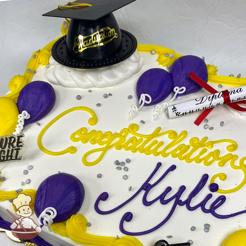 Sheet cake with white frosting, decorated with a black plastic graduation cap, purple and yellow buttercream balloons, silver sprinkles, and a paper diploma.