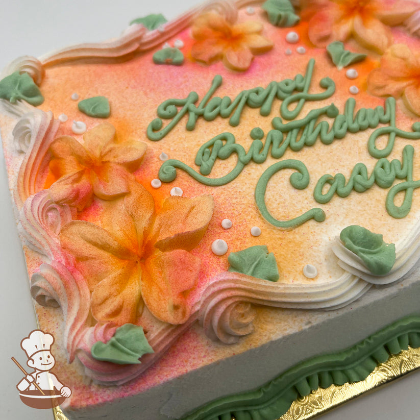 Sheet cake with orange and pink airbrushed flowers, decorated with plumeria flowers, green leaves, white dots, and piped swirl trims.
