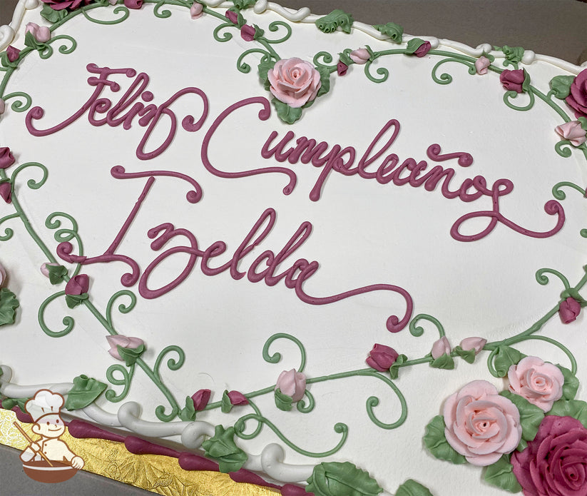 Sheet cake with white frosting, decorated with pink roses, rosebuds, and green vines forming a heart-shaped border.