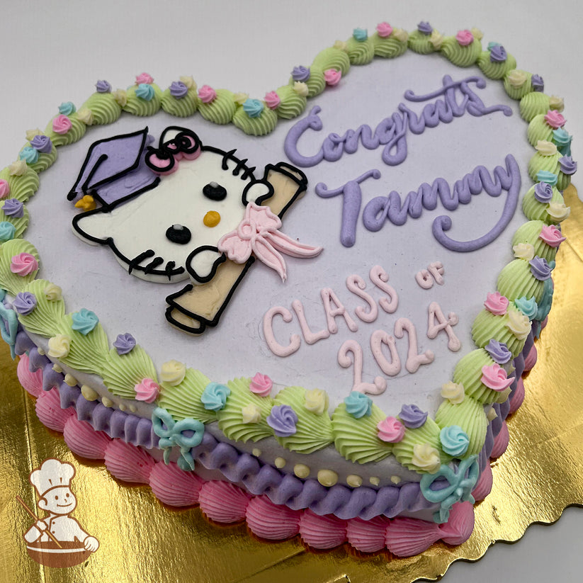 Heart-shaped cake with a pastel purple base, featuring a buttercream Hello Kitty face wearing a graduation cap and holding a diploma with a pink bow. Decorated with vintage-style pastel piping, small buttercream flowers, and buttercream bows along the edges.