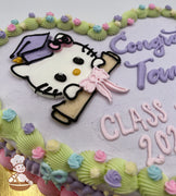 Heart-shaped cake with a pastel purple base, featuring a buttercream Hello Kitty face wearing a graduation cap and holding a diploma with a pink bow. Decorated with vintage-style pastel piping, small buttercream flowers, and buttercream bows along the edges.