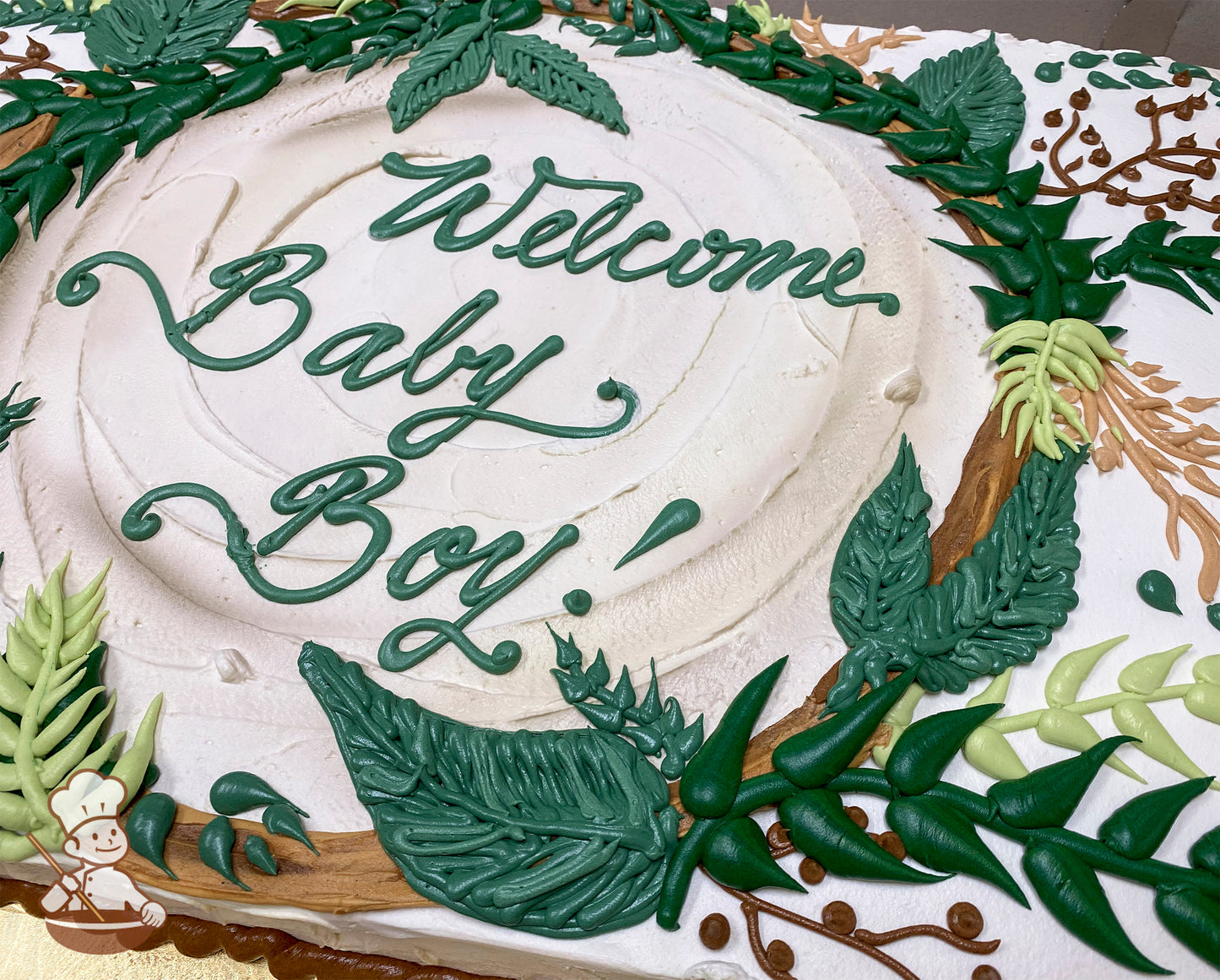 Sheet cake with white frosting, decorated with a jungle-themed frame of green leaves, vines, and small brown and floral accents.