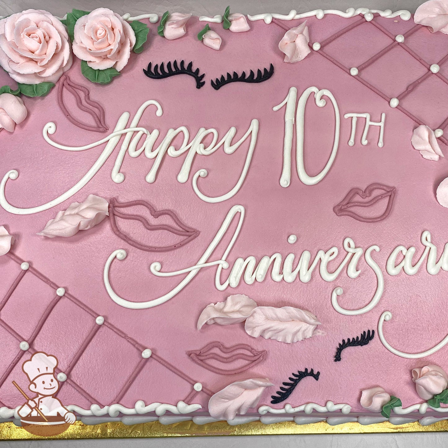 Pink sheet cake with buttercream roses, piped lips, eyelashes, and feathers. Decorative lattice design with dot accents on the edges.