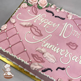 Pink sheet cake with buttercream roses, piped lips, eyelashes, and feathers. Decorative lattice design with dot accents on the edges.
