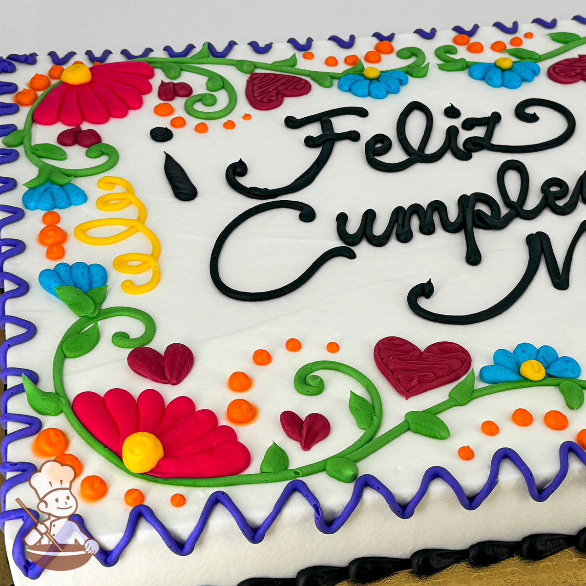 Sheet cake with colorful buttercream decorations, featuring flowers, vines, dots, leaves, and hearts in a Mexican Fiesta embroidery style.