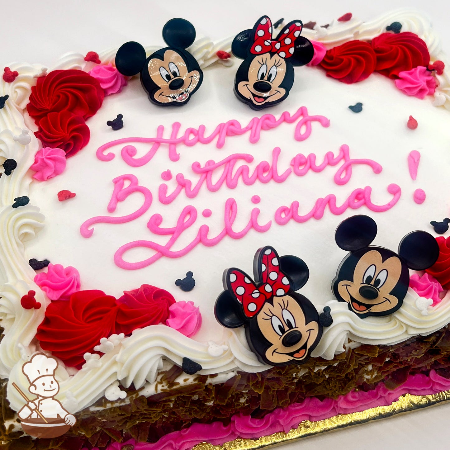 Sheet cake with Mickey and Minnie Mouse plastic rings, red and pink buttercream swirls, and Mickey Mouse sprinkles.