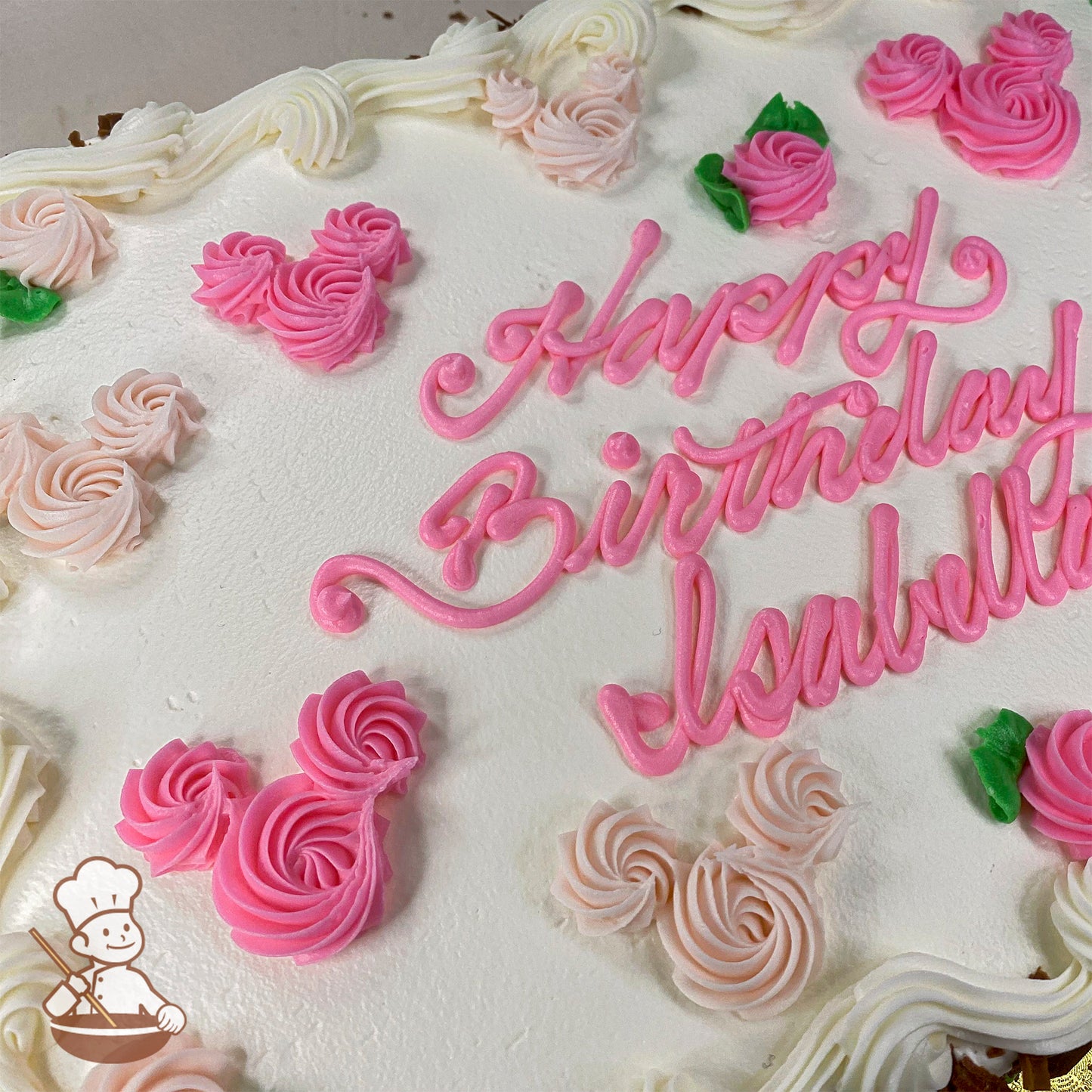 White sheet cake with pink buttercream Minnie Mouse-shaped swirls, pink and white rosettes, green leaves, and piped white border.