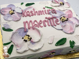 Sheet cake with white frosting, decorated with pastel painted flowers in pink, purple, and yellow, and green leaves.