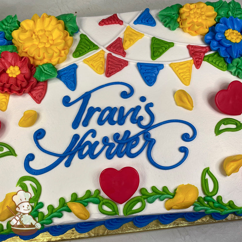 Sheet cake with white frosting, colorful buttercream party banners, yellow and red camellia flowers, green leaves, and red plastic heart decorations.