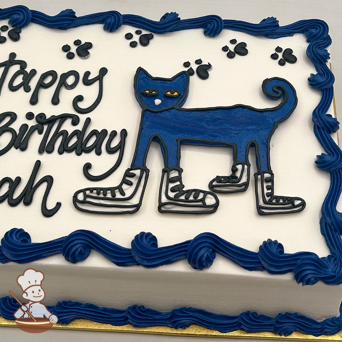Sheet cake with a buttercream decoration of Pete the Cat wearing sneakers, surrounded by black paw prints and bordered with blue frosting swirls.