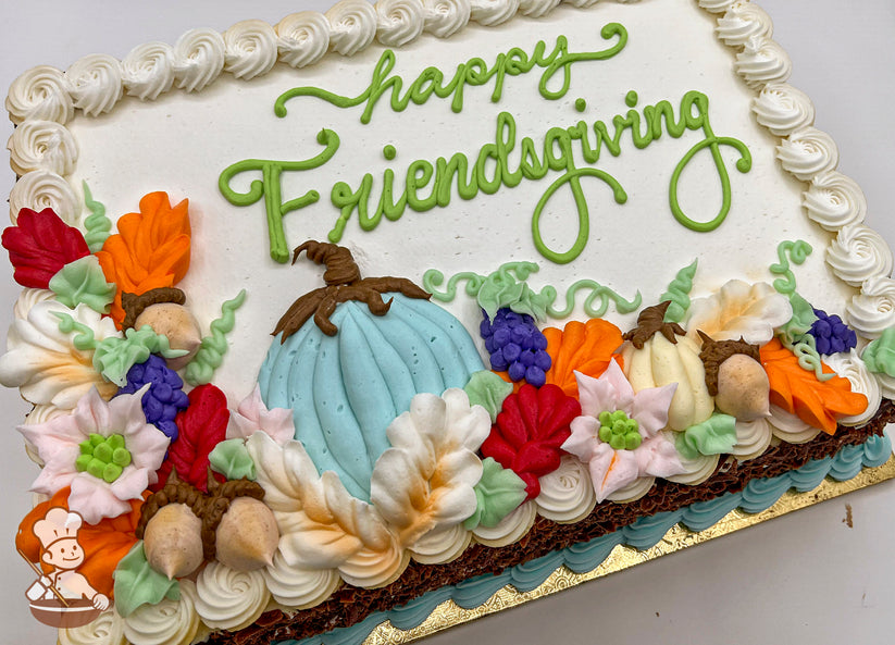 Sheet cake with buttercream decorations, featuring a blue pumpkin, orange and white flowers, acorns, purple grapes, swirl trim, and colorful leaves.