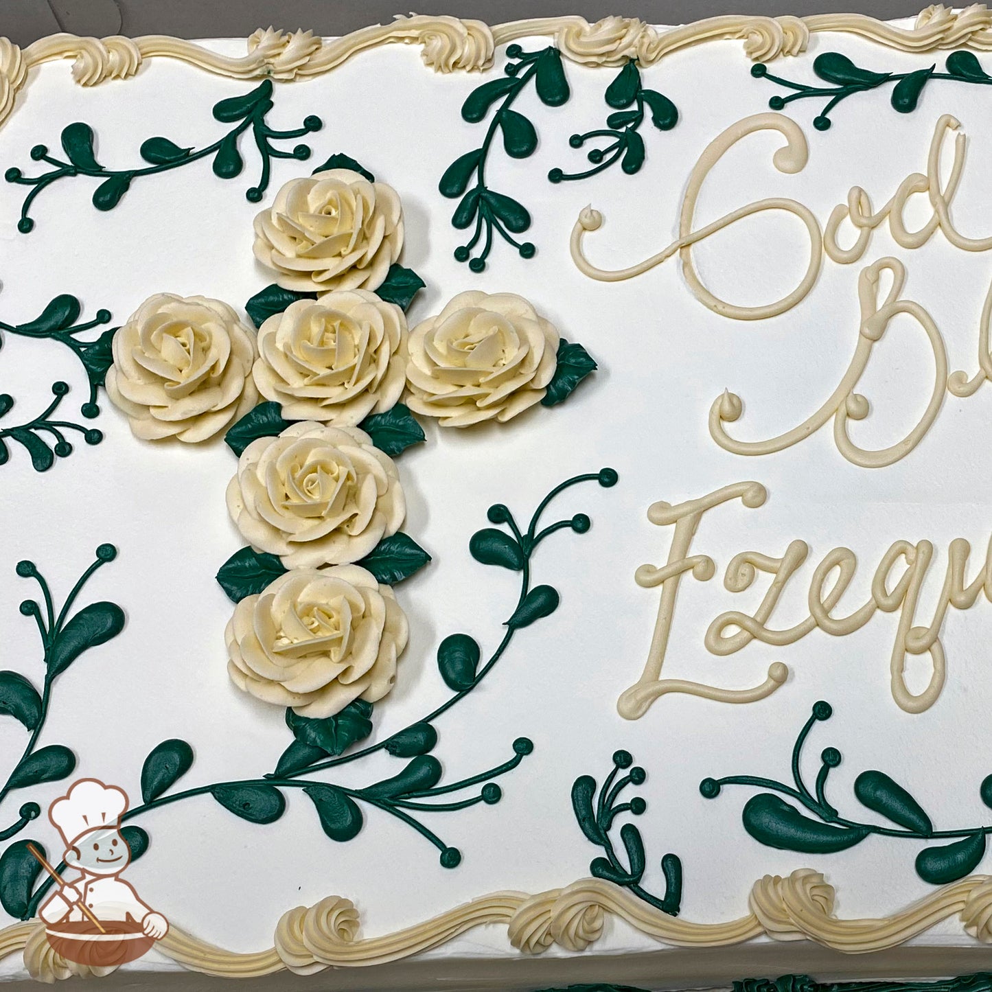 Sheet cake with buttercream decorations featuring a cross made of cream-colored roses and green leaves, surrounded by green vine designs and a cream border.