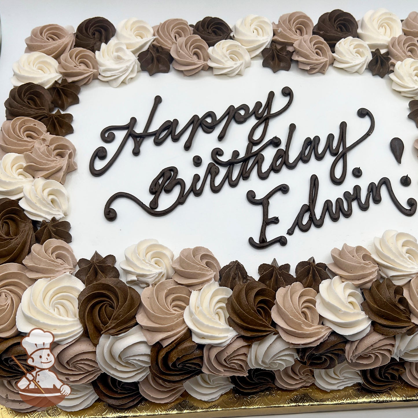Sheet cake with a white base, decorated with a partial wrap of rosette swirls in brown, light brown, and white, accented with small star-shaped swirls.
