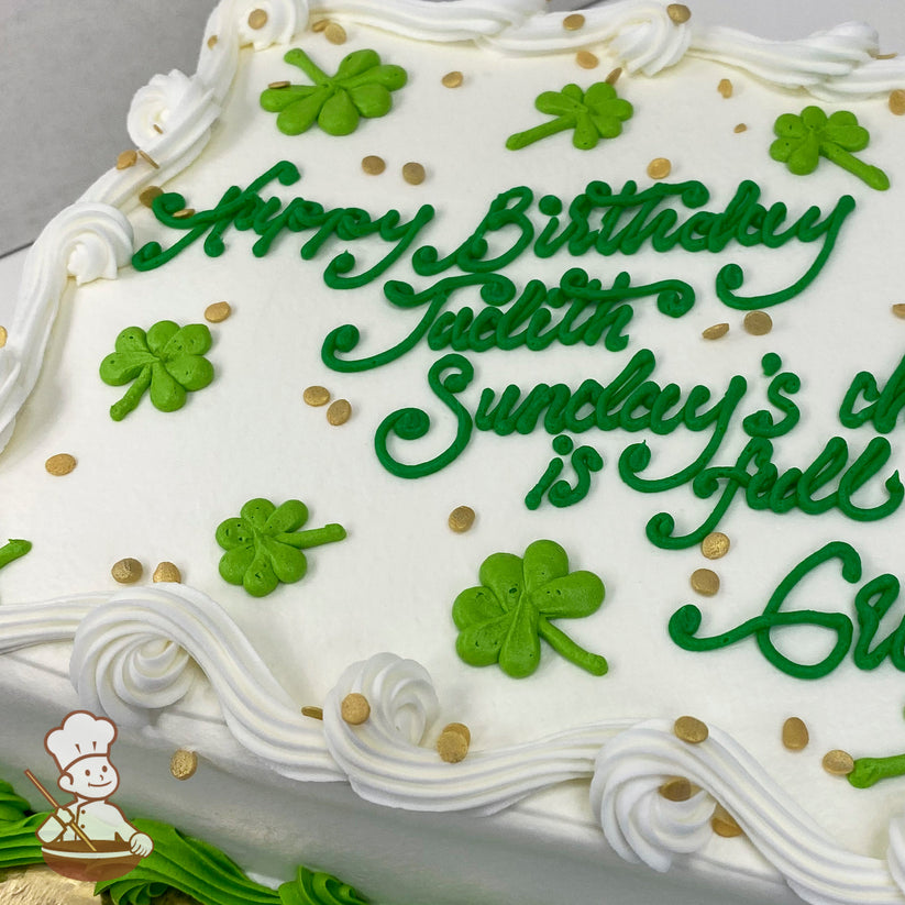 White sheet cake with green buttercream shamrocks, gold sprinkle accents, and white piped borders. Shamrocks and sprinkles are evenly scattered.