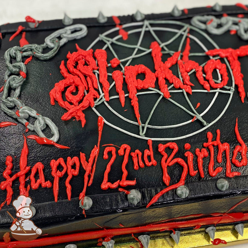 A black sheet cake with red buttercream text, a pentagram design, gray buttercream chains, and spikes along the edges for decoration.