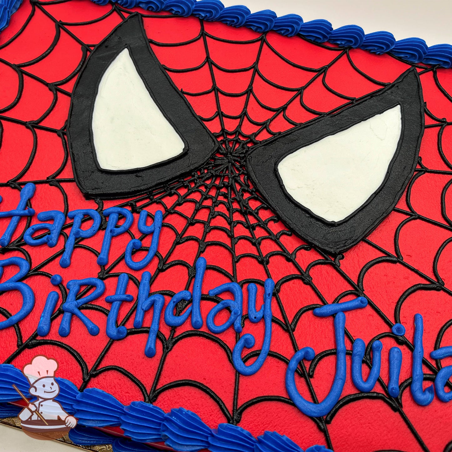 Sheet cake with a red base, black spider web design, large Spider-Man eyes in black and white icing, and blue piped border.