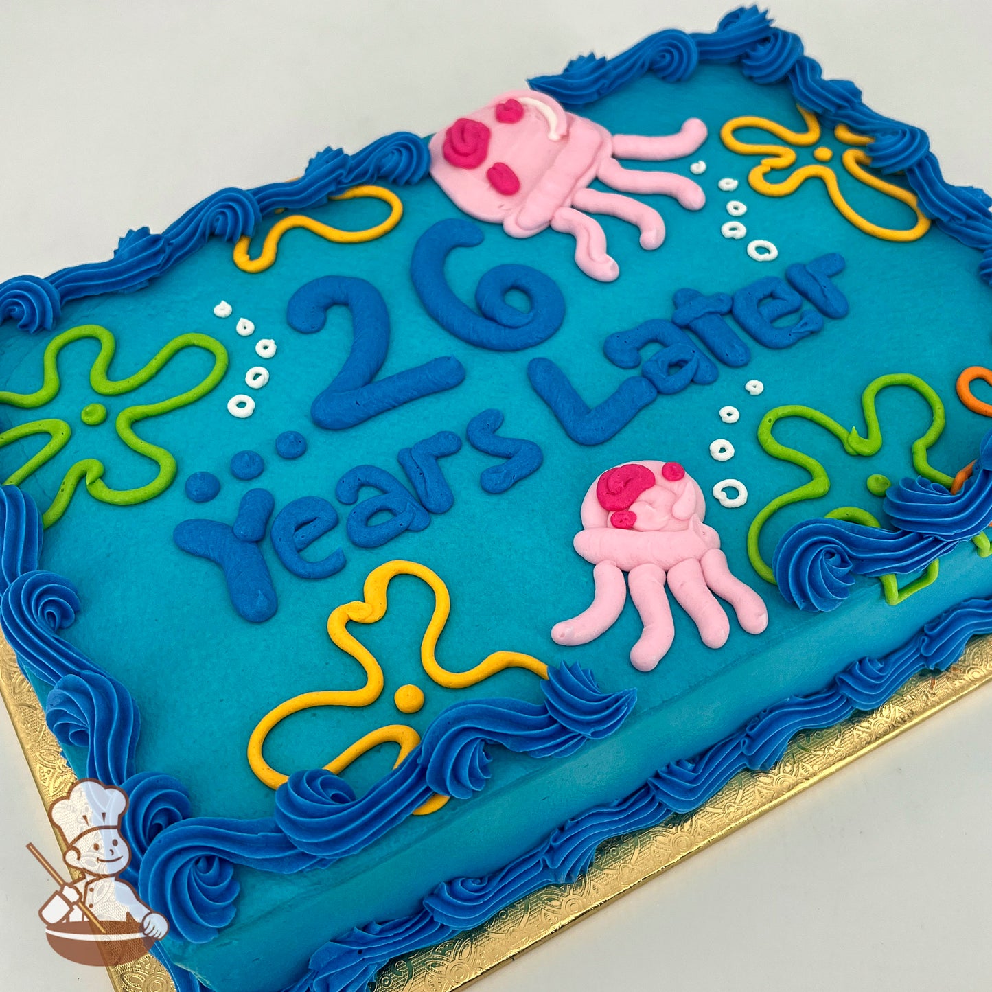 Blue sheet cake with buttercream decorations of pink jellyfish, yellow, orange and green SpongeBob flower clouds, white bubbles, and blue frosting borders.