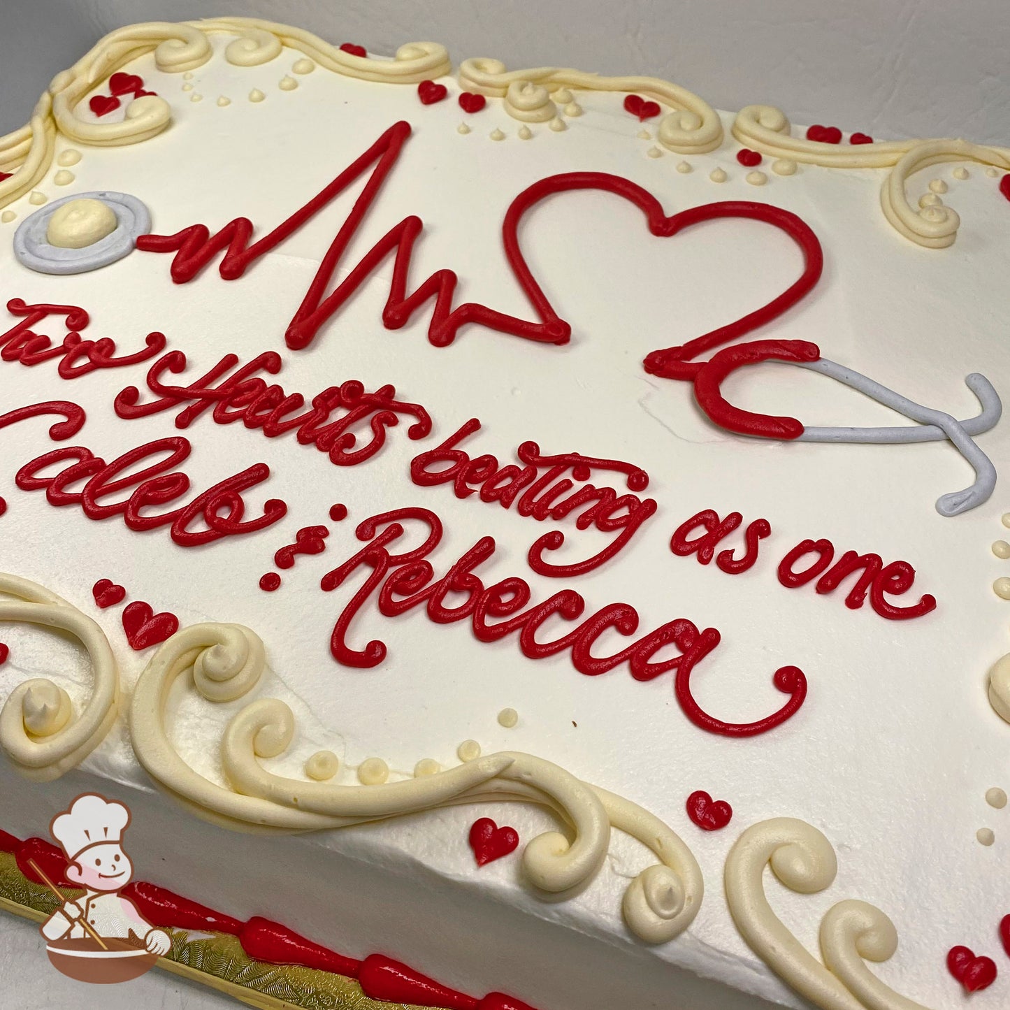 Sheet cake with buttercream stethoscope and EKG heartbeat design, adorned with cream swirls and small red heart decorations.