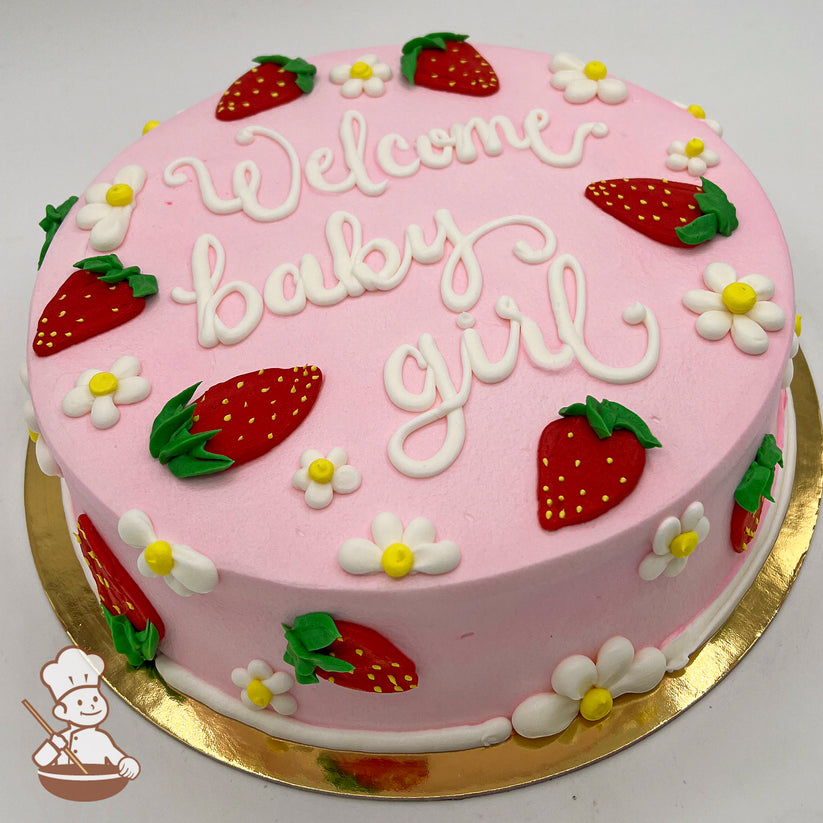 Round pink sheet cake with buttercream strawberries and daisies as decorations. Strawberries are red with green tops, and daisies are white with yellow centers.