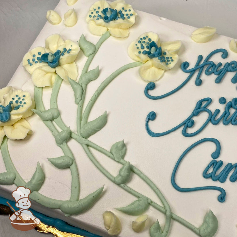 Sheet cake with white frosting, decorated with pale yellow flowers featuring blue centers, green stems, and leaves piped in buttercream.