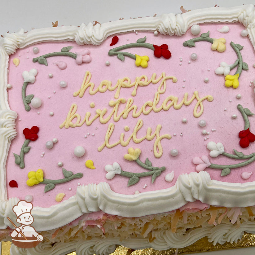 Sheet cake with pink frosting, white lace-like trim, floral decorations in red, yellow, and white, and scattered pearl-like beads.
