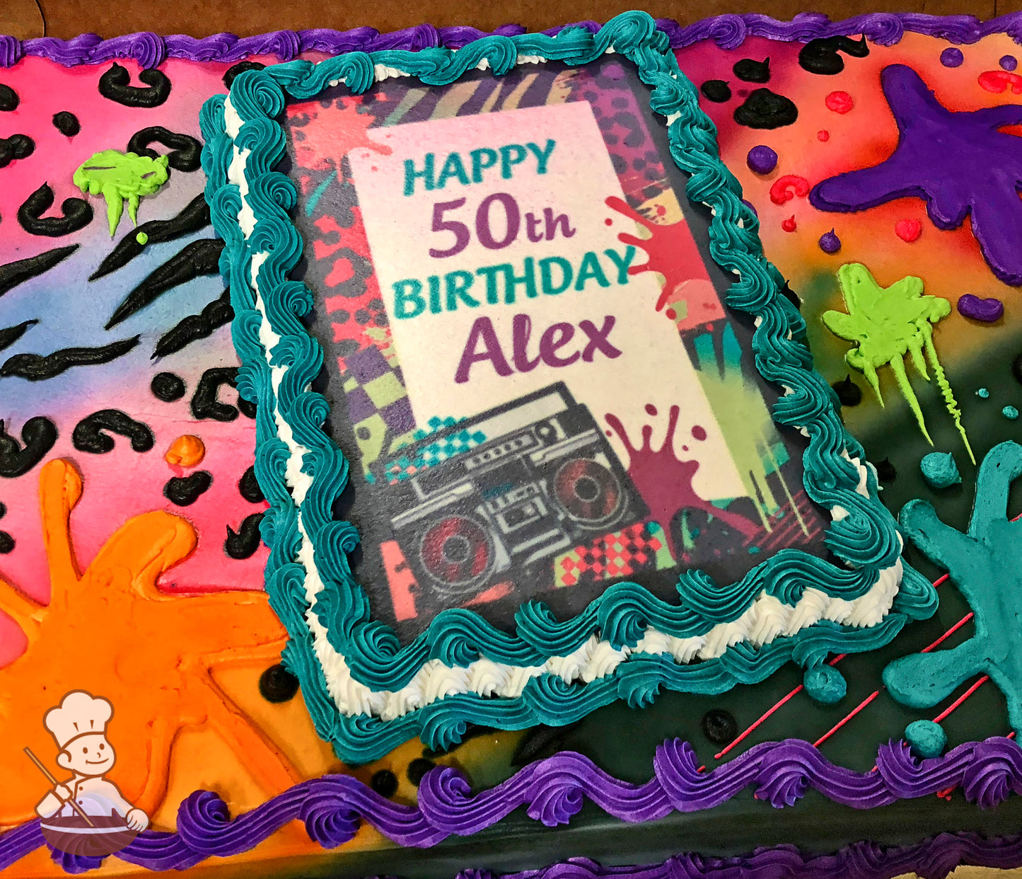 Sheet cake with vibrant buttercream decorations, including colorful paint splatters, animal print patterns, and piped teal and purple borders.