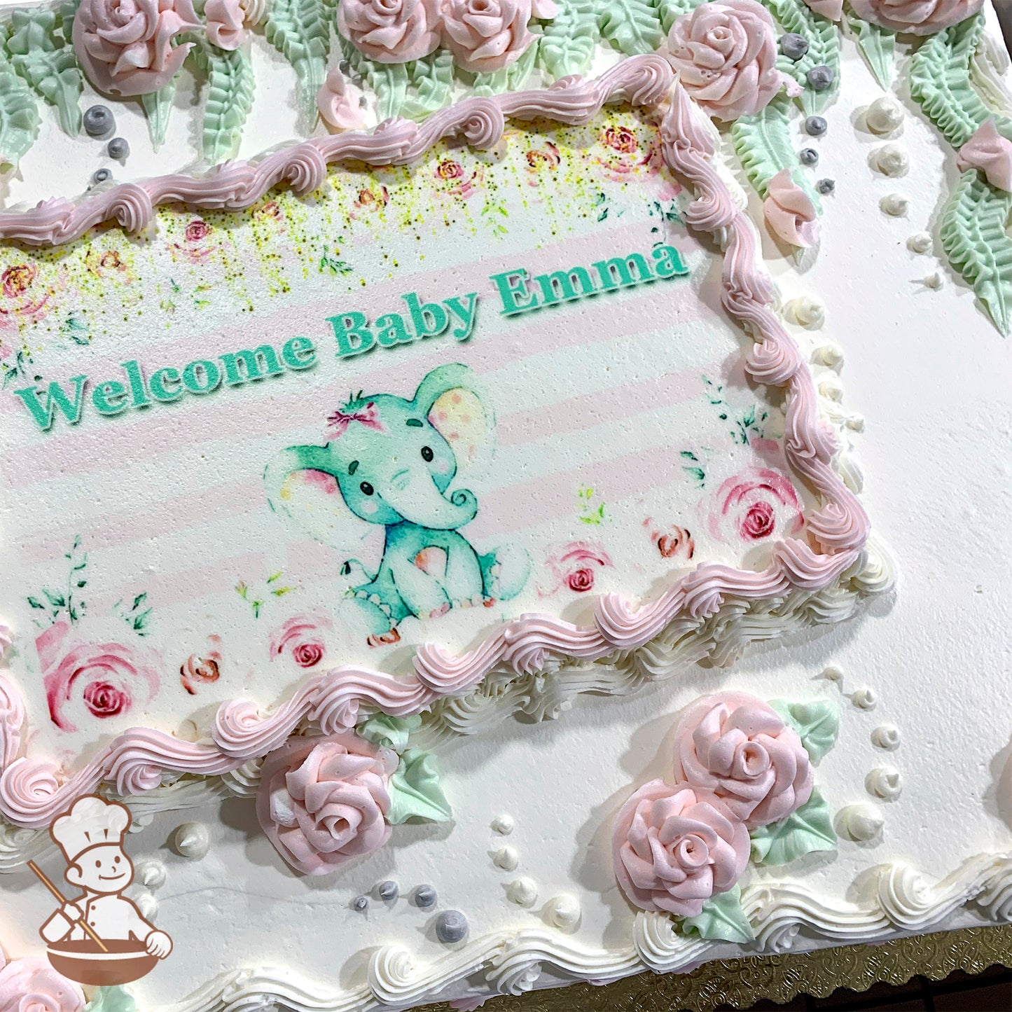 Sheet cake with pink buttercream roses, green leaves, and vine decorations.