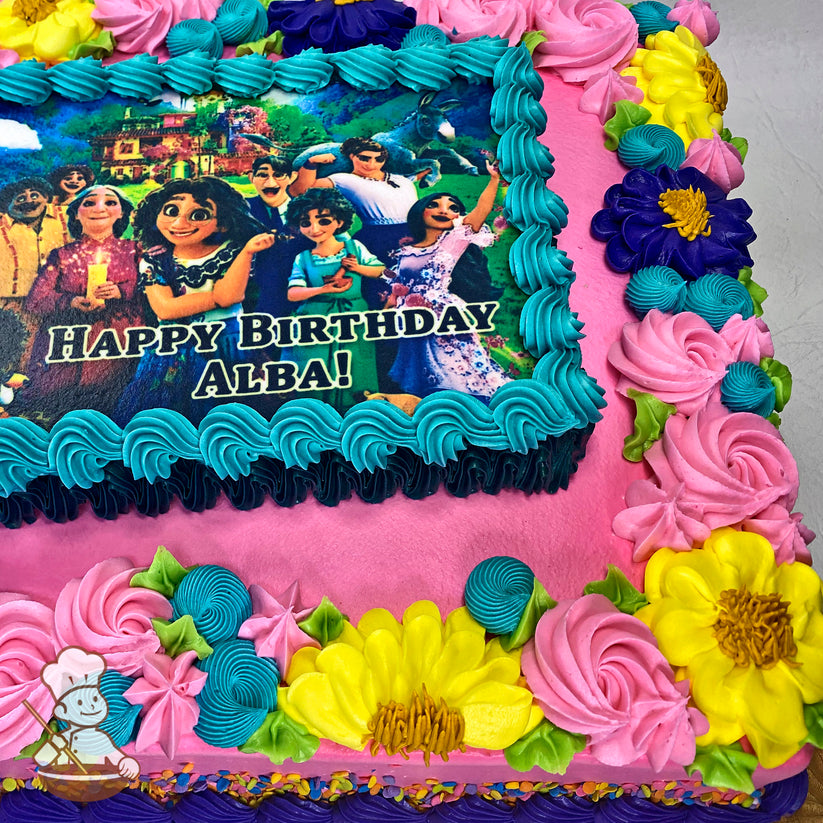 Sheet cake with pink frosting, blue and pink rosettes, yellow and purple flowers, green leaves, and a blue border around a printed photo layer.