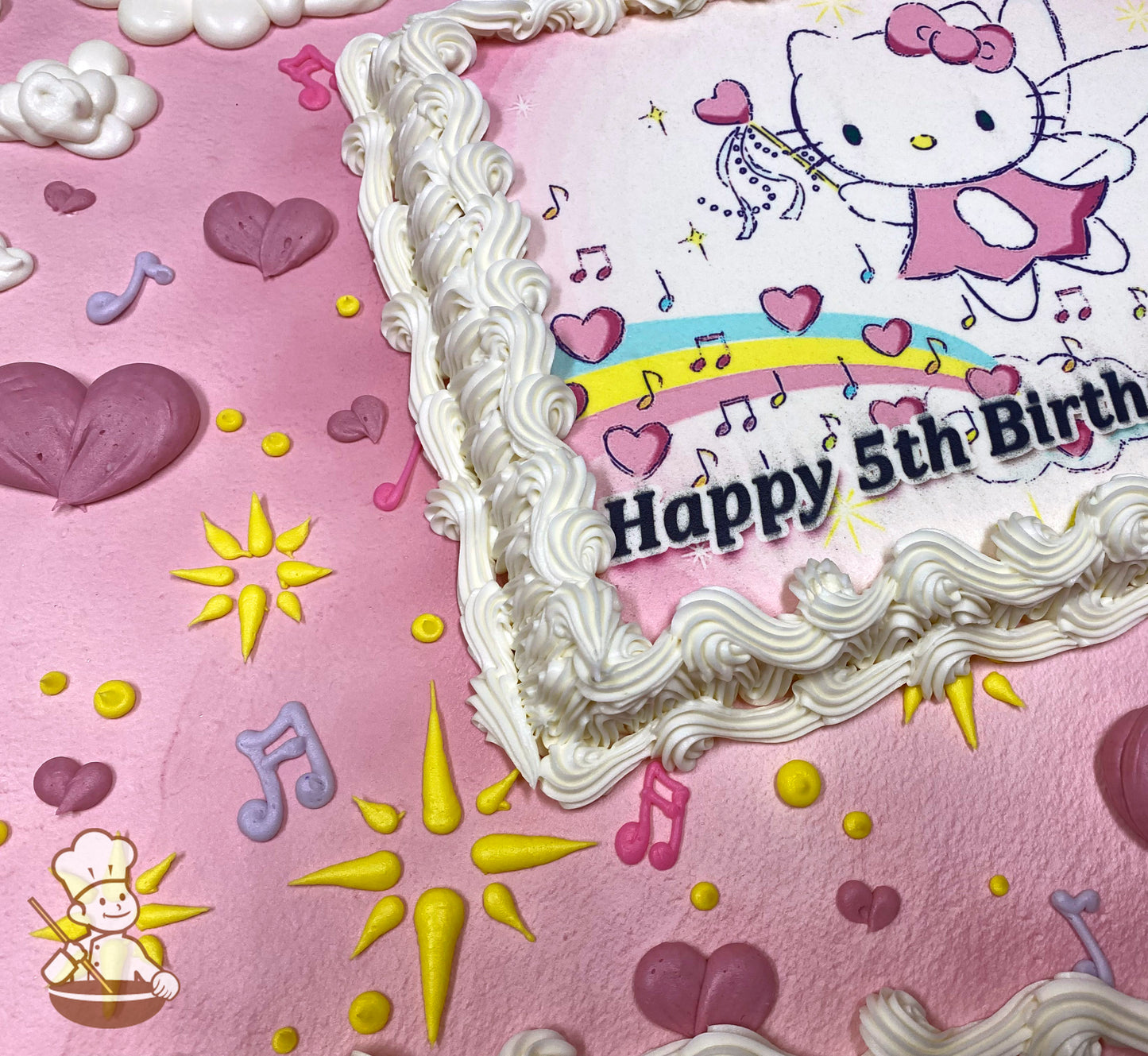 Pink sheet cake with white buttercream borders, decorated with piped hearts, sparkles, music notes, and clouds in pastel colors.