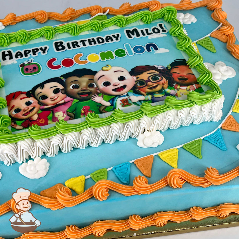 Sheet cake with a blue base, orange, white and green piped borders framing a printed photo, and colorful banner decorations.