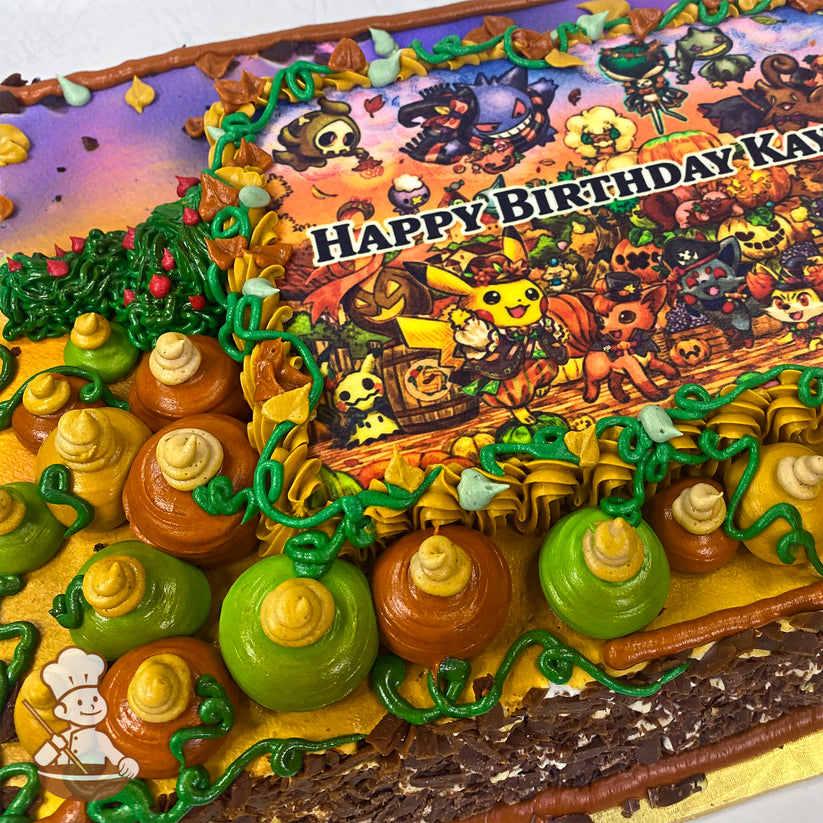 Sheet cake with colorful buttercream pumpkins, green vines, and autumn leaves surrounding a printed image.