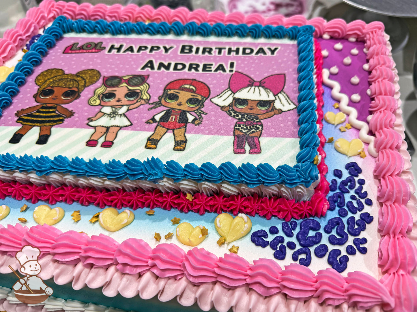 Sheet cake with pink, blue, and white buttercream borders, yellow heart decorations, and purple leopard print accents.