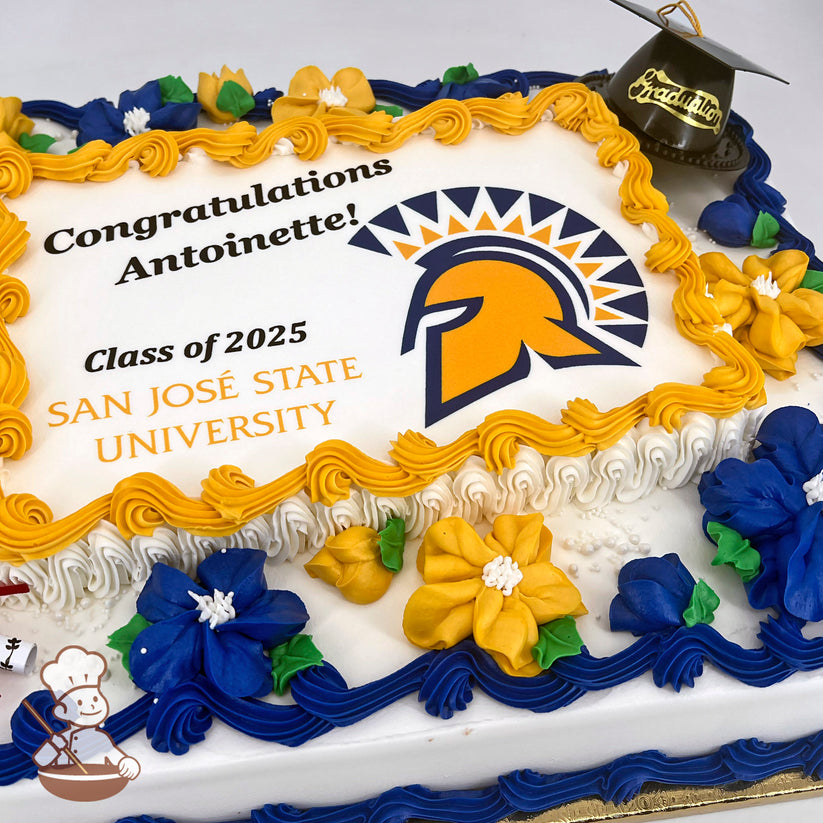 Sheet cake with yellow and blue buttercream Hawaiian flowers, blue and yellow piped borders, and a small plastic graduation cap decoration.