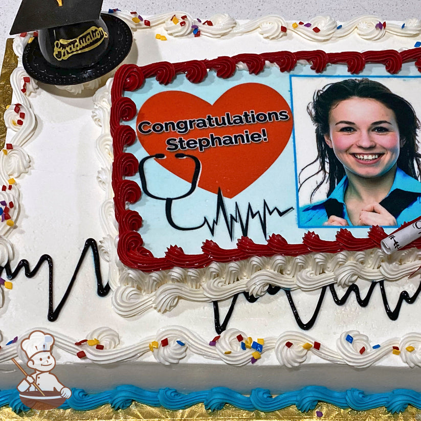Sheet cake with white icing, red and blue piped borders, black heartbeat design, colorful sprinkles, and a plastic graduation cap decoration.